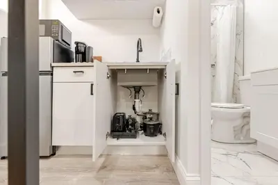a white kitchen with a sink and a toilet at Miami North Beach in North Miami Beach