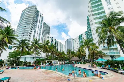 a swimming pool in a resort with palm trees and buildings at Condo on the beach Hollywood 6th floor in Hollywood