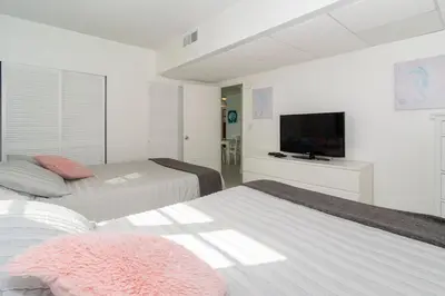 a bedroom with two beds and a flat screen tv at Condo on the beach Hollywood 6th floor in Hollywood