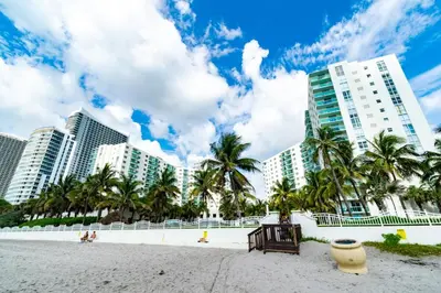 a beach with palm trees and tall buildings at Condo on the beach Hollywood 6th floor in Hollywood
