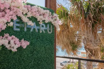 a sign with pink flowers on a fence at Beautiful studio in Beachwalk 2QB in Hallandale Beach