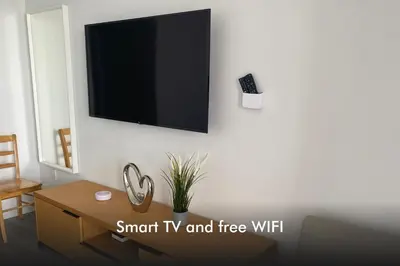 a living room with a tv on a white wall at BeachWalk Studio Apmt 2 Beds w Beach Service in Hallandale Beach