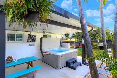 a hot tub and bench on a patio with palm trees at 2BR, Families, Pets, Medical Stays, Hot Tub in Miami