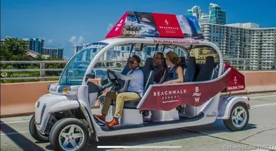 a group of people sitting in a golf cart at Miami Beach 1B 1B w Kitchen and Beach Service in Hallandale Beach