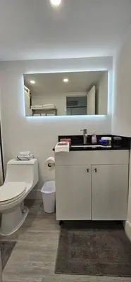a bathroom with a white toilet and a mirror at City view with balcony on the Beach in Sunny Isles Beach