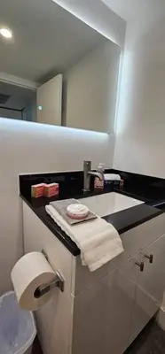 a bathroom with a sink and a toilet and a mirror at City view with balcony on the Beach in Sunny Isles Beach