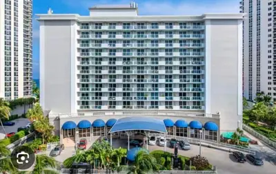 a large hotel building with a parking lot at City view with balcony on the Beach in Sunny Isles Beach
