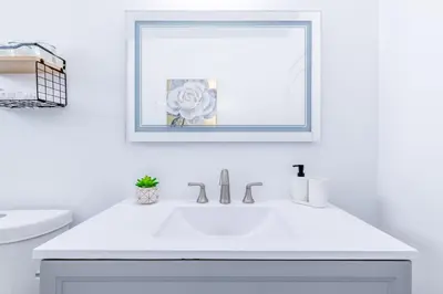 a white bathroom with a sink and a mirror at Hard Rock Paradise in Andover Lakes Estates