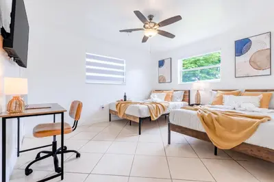 a bedroom with two beds and a desk at Hard Rock Paradise in Andover Lakes Estates