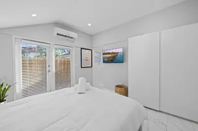 a white bedroom with a large white bed at Beach Home in Victoria Park in Fort Lauderdale