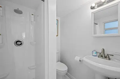 a white bathroom with a toilet and a sink at Beach Home in Victoria Park in Fort Lauderdale