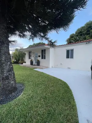 a white house with a tree in front of it at Beautiful House in Coral Gables FL in Miami