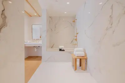 a white bathroom with a sink and a stool at Donatella Boutique Hotel in Miami Beach