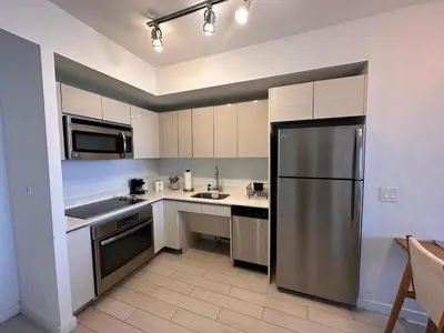 a kitchen with a stainless steel refrigerator and appliances at Cozy 1BR Retreat wPool BeachService & Full Kitchen in Hallandale Beach
