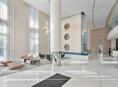 a lobby of a building with tables and chairs at BrickellRiver LOFT with parking & 12 min to South Beach in Miami