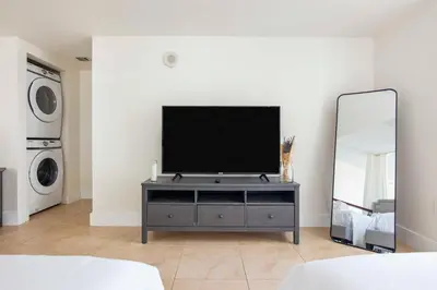a living room with a tv and a mirror at BrickellRiver LOFT with parking & 12 min to South Beach in Miami