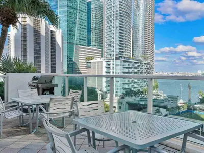 a table and chairs on a balcony with a view of the city at BrickellRiver LOFT with parking & 12 min to South Beach in Miami