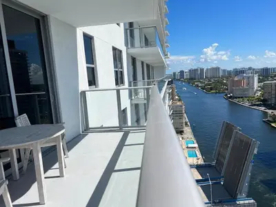 a balcony of a building with a view of a river at Beachfront Apt with Gym, Pool, and Rest in Miami in Hollywood