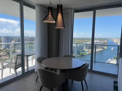 a dining room with a table and chairs and a large window at Apt Hyde, Beach, Pool, and Resort Amenities in Miami in Hollywood