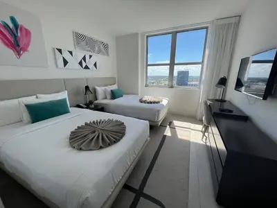 a hotel room with two beds and a television at Hyde Luxury 2 Bedroom Apartment in Miami Beach and Pool in Hollywood