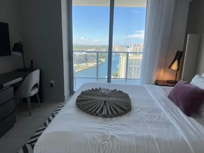 a bedroom with a large bed with a large window at Hyde Luxury 2 Bedroom Apartment in Miami Beach and Pool in Hollywood