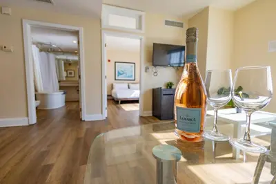 a bottle of wine sitting on a table with two wine glasses at Amazing 1 Bedroom with Rooftop Pool D304 in Miami Beach