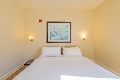 a bedroom with a white bed with a picture on the wall at Amazing 1 Bedroom with Rooftop Pool D304 in Miami Beach