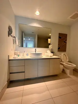 a bathroom with a sink and a toilet and a mirror at Miami Apt with Amazing Views & Kitchen in Hallandale Beach