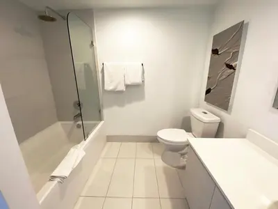 a white bathroom with a toilet and a shower at Miami Apt with Amazing Views & Kitchen in Hallandale Beach