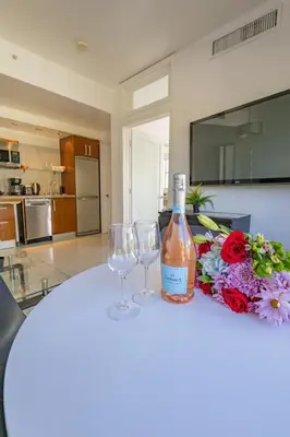 a bottle of wine and two wine glasses on a table at Beautiful 1 bedroom with Rooftop Pool D209 in Miami Beach