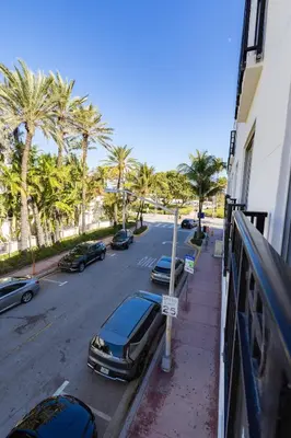 a street with cars parked on the side of a street with palm trees at Beautiful 1 bedroom with Rooftop Pool D209 in Miami Beach