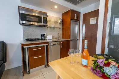 a kitchen with a wooden table with wine glasses on it at Beautiful Studio with Rooftop pool B309 in Miami Beach