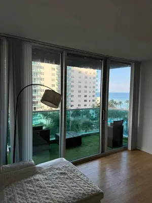 a bedroom with a large window with a view of the ocean at beautiful place 1 in Hollywood