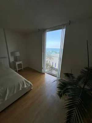 a bedroom with a large window with a view of the ocean at beautiful place 1 in Hollywood