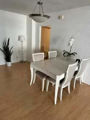a dining room table with white chairs and a table at beautiful place 1 in Hollywood