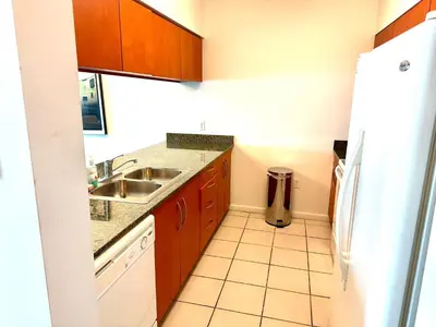 a small kitchen with a sink and a refrigerator at 1BR Brickell included Pool, Gym and Free Parking in Miami