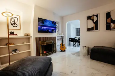 a living room with a fireplace and a flat screen tv at Miami Palms Serene in Miami
