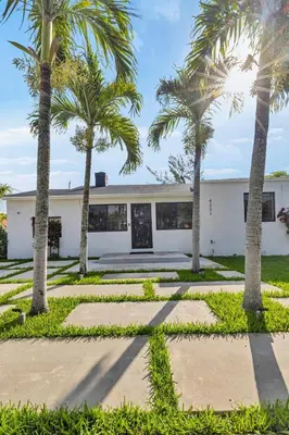 a house with palm trees in front of it at Miami Palms Serene in Miami