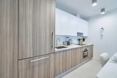 a kitchen with wooden cabinets and a sink at Central Brickell Condo Walk to Shops & Dining in Miami