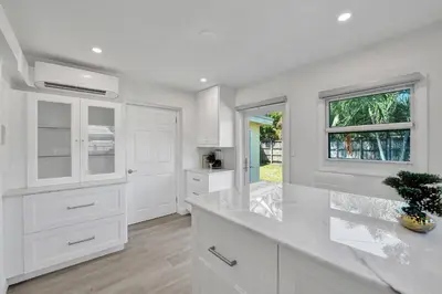 a white kitchen with white cabinets and a window at Private Room in Spacious 3-Bedroom Home in Fort Lauderdale