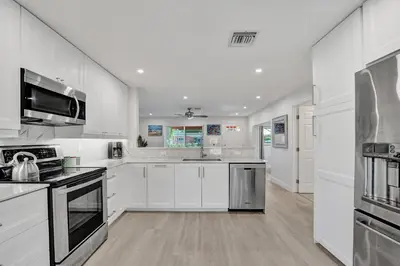 a kitchen with white cabinets and stainless steel appliances at Private Room in Spacious 3-Bedroom Home in Fort Lauderdale