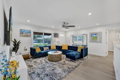 a living room with blue couches and a table at Private Room in Spacious 3-Bedroom Home in Fort Lauderdale
