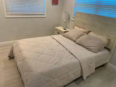 a bedroom with a large bed with a wooden headboard at Private Room in Spacious 3-Bedroom Home in Fort Lauderdale