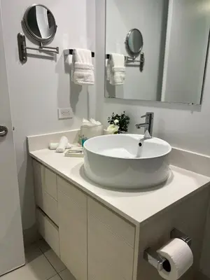 a bathroom with a sink and a mirror at Studio 2 beds queen, pool, gym and service beach in Hallandale Beach