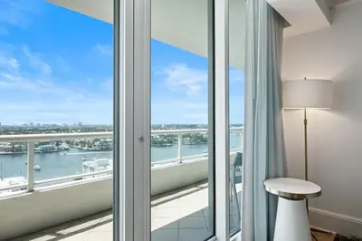 a room with a balcony with a view of the water at Beachfront Ritz-Carlton Luxury 1BR Residence in Fort Lauderdale