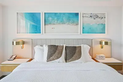 a bedroom with a white bed with two nightstands and two lamps at Beachfront Ritz-Carlton Luxury 1BR Residence in Fort Lauderdale