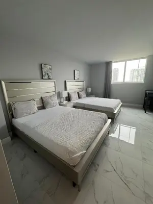 a bedroom with two beds and two windows at Modern Apartments Ocean Reserve Sunny Isles Beach in Sunny Isles Beach