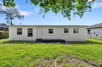 a white house with a large yard at 4BR Escape Near Beach & Downtown in Fort Lauderdale