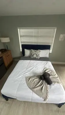 a bedroom with a large white bed with a window at Charming 1BR Escape Near Hollywood & Dania in Dania Beach