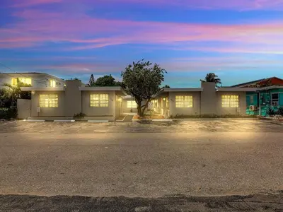a house with lights on in a parking lot at Hollywood Beach 1BR Getaway | WiFi + AC in Dania Beach